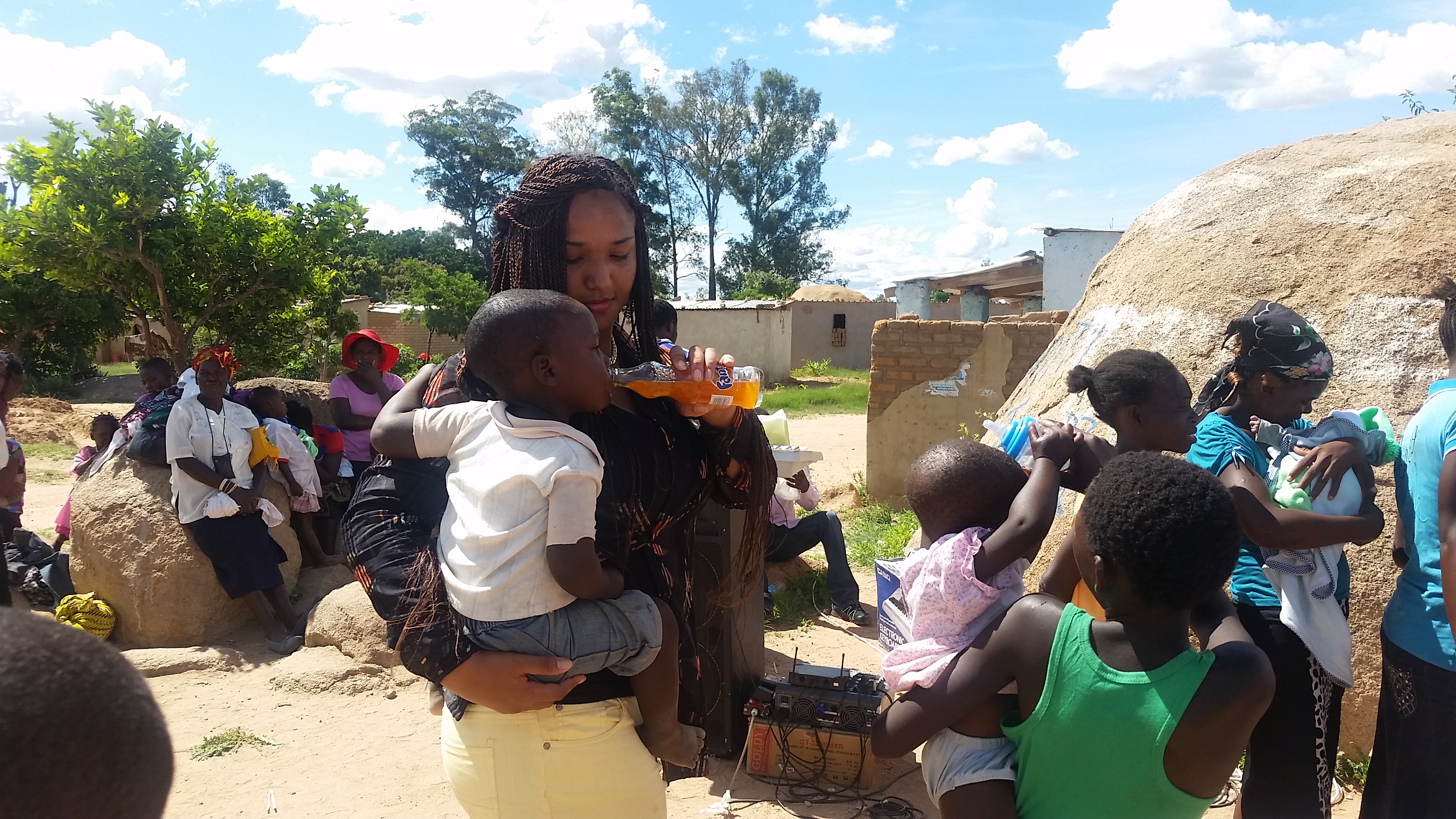 Mama Nelly shares a refreshing bottle of Fanta with one of the children